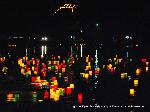 京の夏 : 鳥居に焚かれる送り火の麓に五色の灯籠流し