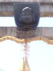 恵比寿 : 恵比寿神社の境内の鳥居には恵比寿さんの面。その下の熊手にお金が。